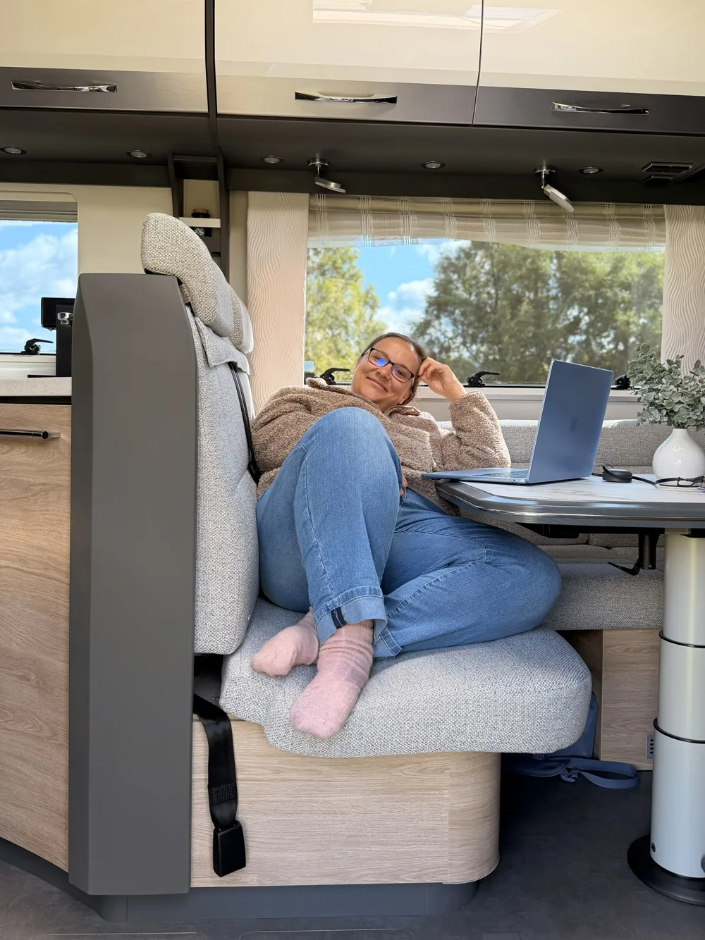 Maria arbeitet mit dem Laptop am Tisch im Wohnmobil
