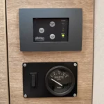 Bedienfeld der Zerhackertoilette mit den Tasten Short Use, Before Use und After Use sowie der Tankanzeige, darunter die Rundanzeige für den Abwassertank.