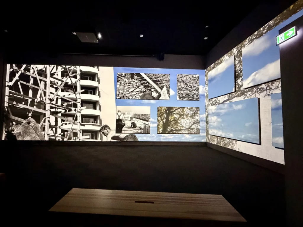 Dunkler Ausstellungsraum im IKEA Museum, an den Wänden großformatige Schwarzweißfotos von Baustellen und Gerüsten.