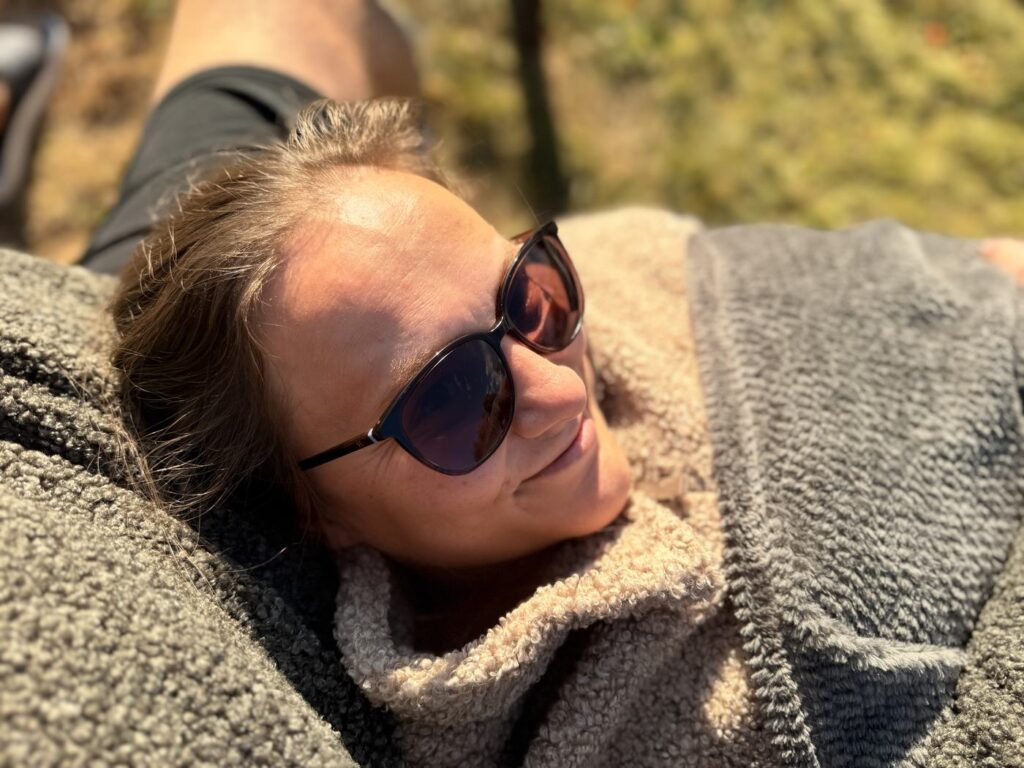 Maria liegt mit Sonnenbrille in der Sonne am River Lodge Camping in Nyfors