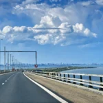 Blick über die Fahrbahn der Öresundbrücke Richtung Dänemark, am Horizont die Skyline von Kopenhagen