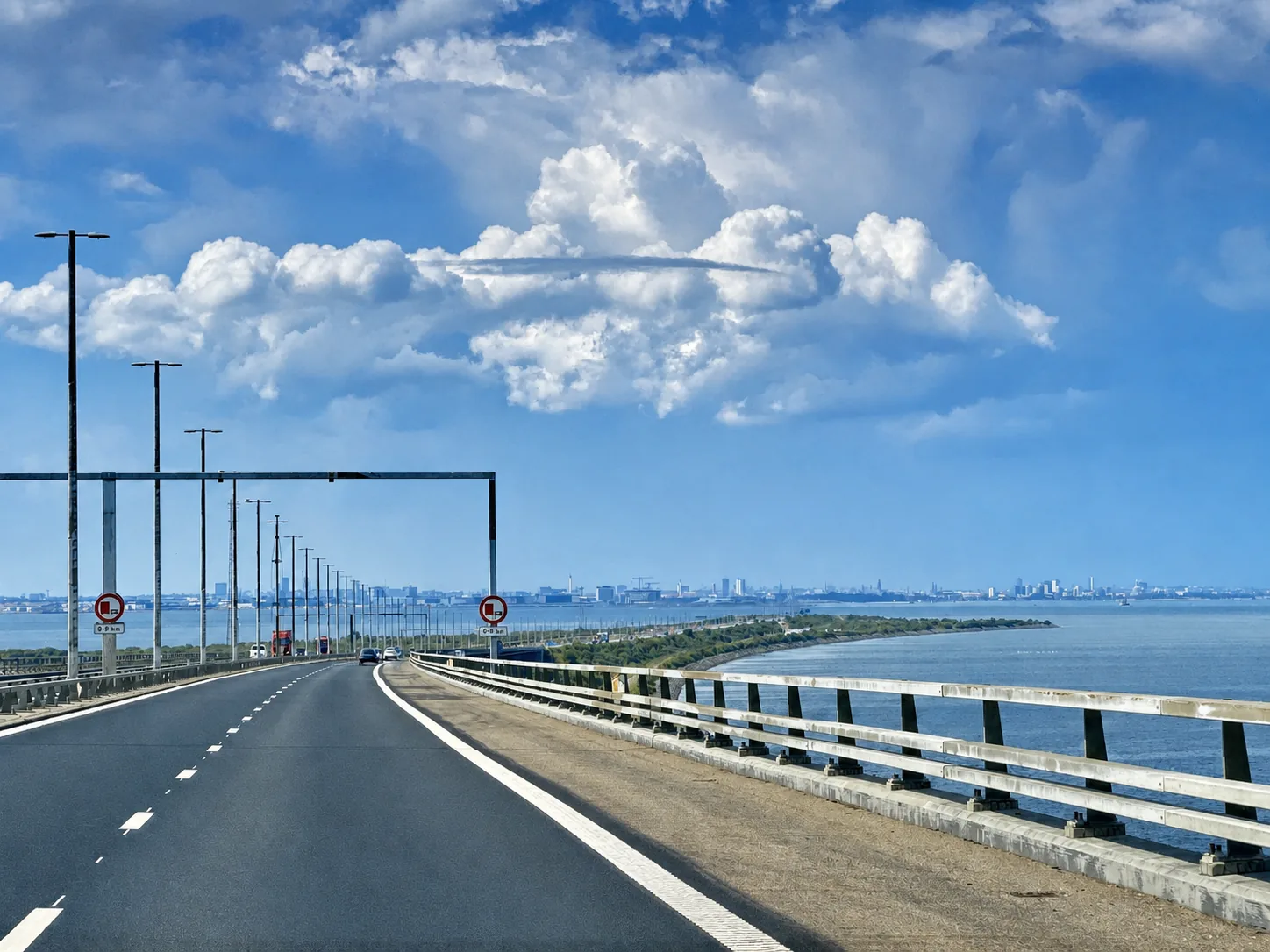 Blick über die Fahrbahn der Öresundbrücke Richtung Dänemark, am Horizont die Skyline von Kopenhagen