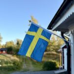 Schwedische Flagge an einem roten Holzhaus in Nyfors