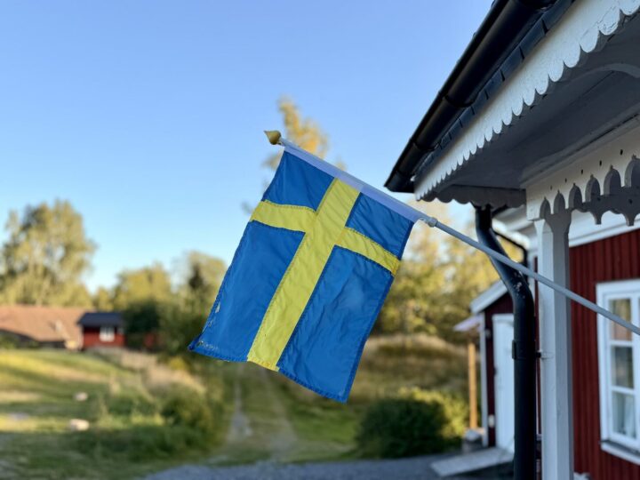 Schwedische Flagge an einem roten Holzhaus in Nyfors