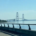 Storebæltbrücke in Dänemark mit der Insel Sprogø und ihrem Leuchtturm, aufgenommen von der Fahrbahn aus