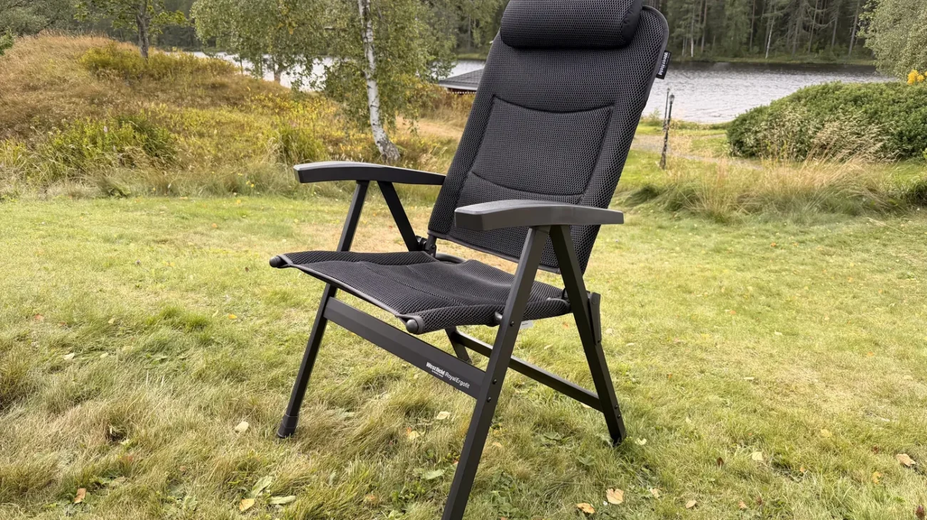Aufgebauter Westfield Royal Ergofit Klappstuhl auf einer Wiese, schwarzer Rahmen mit Mesh-Bespannung und hoher Kopfstütze, im Hintergrund ein See mit Wald in Schweden