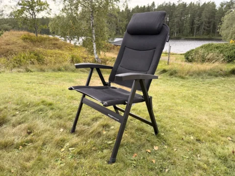 Aufgebauter Westfield Royal Ergofit Klappstuhl auf einer Wiese, schwarzer Rahmen mit Mesh-Bespannung und hoher Kopfstütze, im Hintergrund ein See mit Wald in Schweden