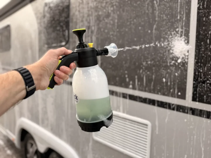 Hand mit der Pumpsprühflasche aus dem CleanTruck Starter Kit, die Schaum auf die bereits eingeschäumte Wand von Luna sprüht.