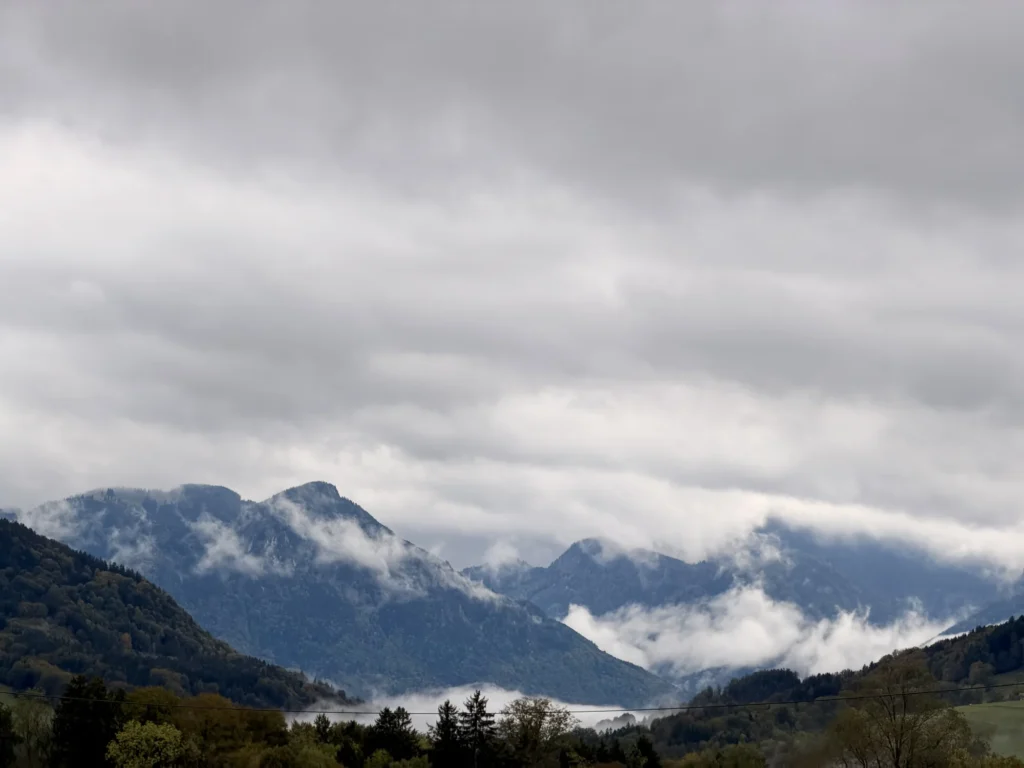 Tief hängende Wolken und Nebelschwaden zwischen den Bergen am Samerberg